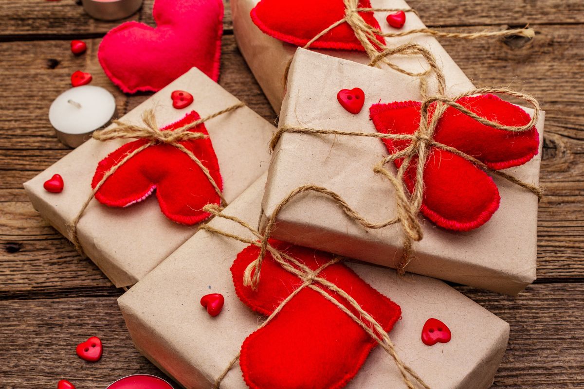 brown paper wrapped gifts with red fabric hearts tied on them 