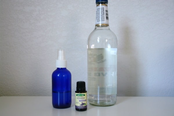 spray bottle, lavender essential oil, vodka on table