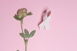 pink ribbon and flower on pink background