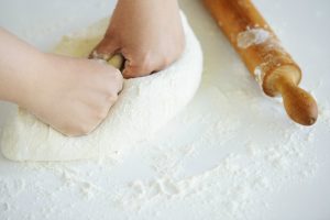 person kneading dough