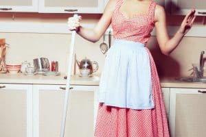1950s housewife washes the floor in the kitchen.