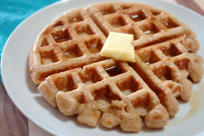 whole wheat waffle on plate with butter and syrup