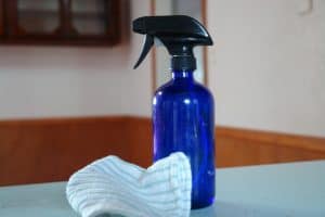 blue spray bottle on aqua countertop with aqua cloth