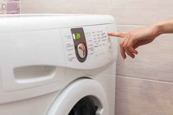person selecting wash cycle on washer
