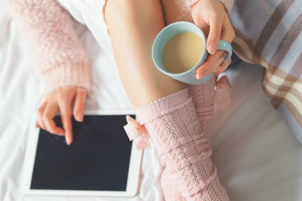 Woman using tablet at cozy home atmosphere on the bed. 