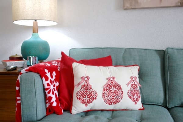 turquoise sofa with red Christmas pillows and blanket