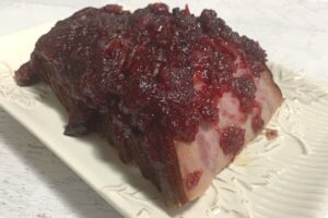 ham with cranberry glaze on white plate