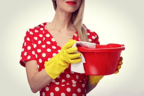 woman in red with white polka dress with yellow cleaning gloves and a red bucket