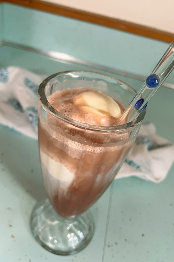 chocolate soda in glass with ice cream and glass straw
