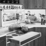 1950s stove in vintage kitchen with family eating in background